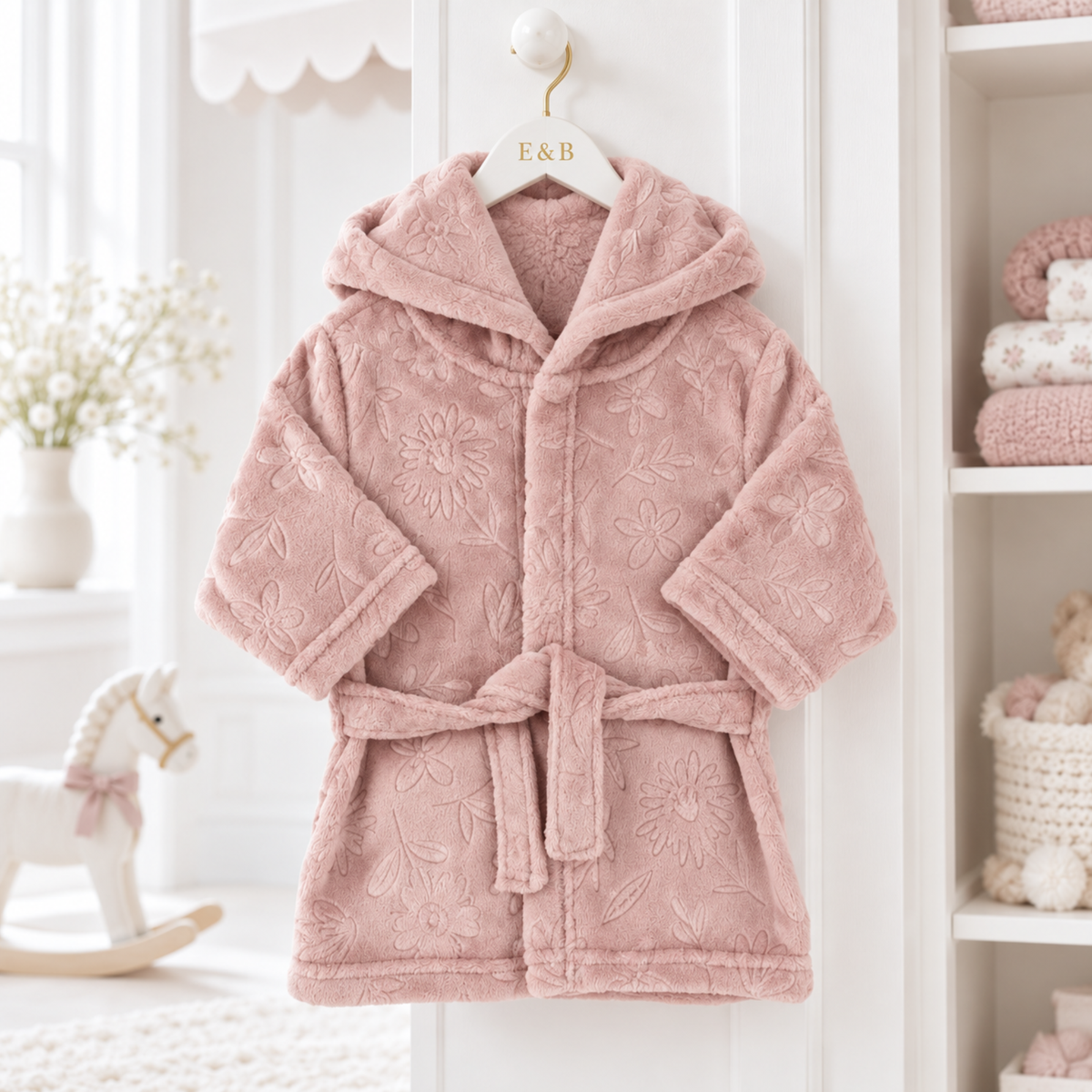 Dusty pink hooded baby dressing gown with embossed floral pattern, plush fabric and matching waist tie
