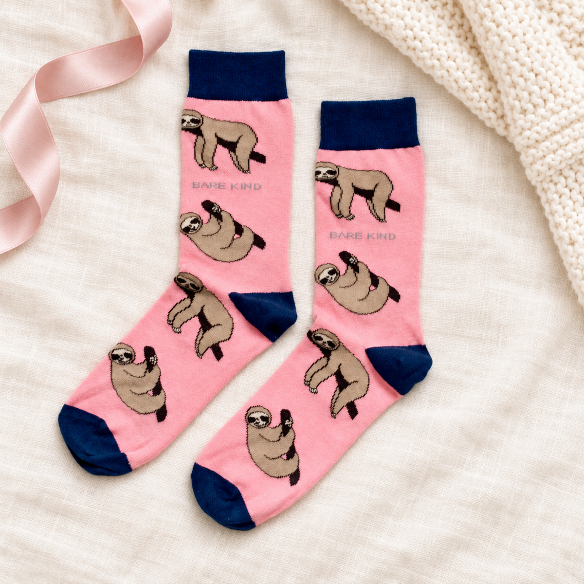 Bare Kind pink bamboo socks with sloth print and navy cuffs