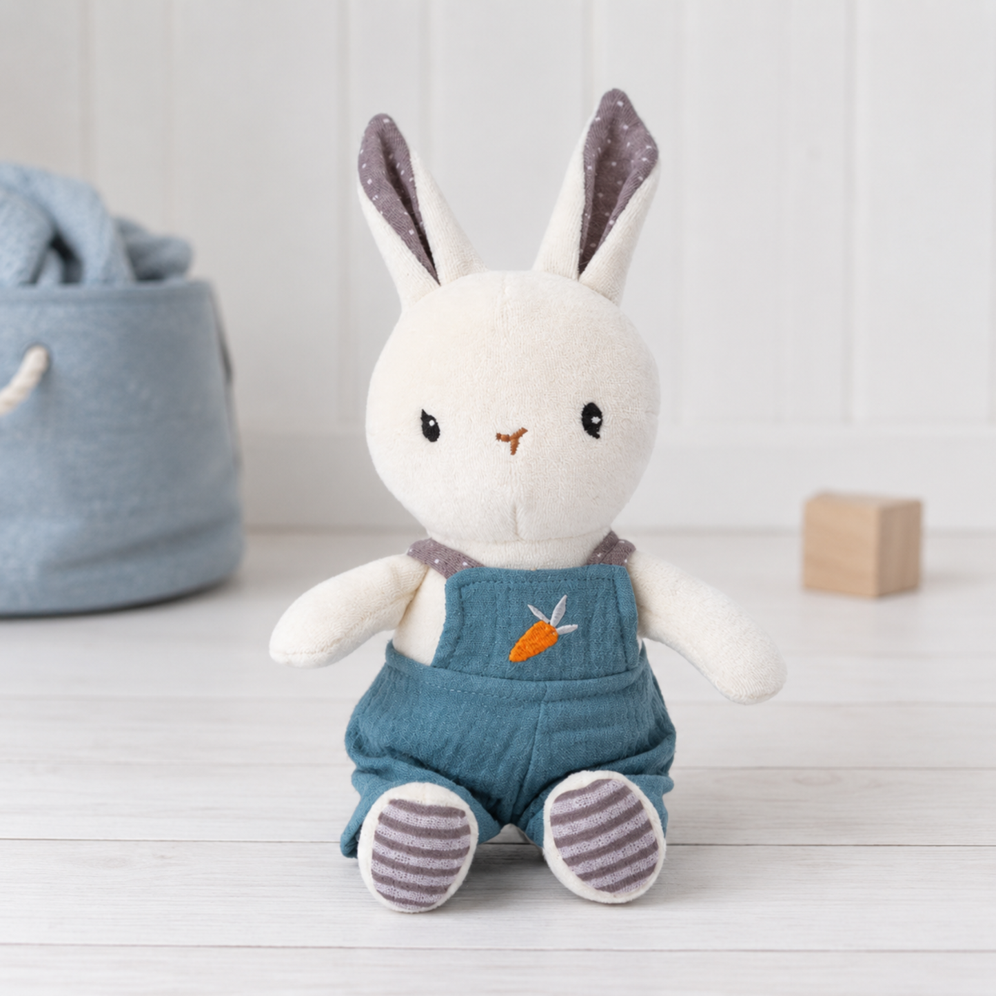 Small white rabbit organic cotton baby soft toy wearing blue dungarees with carrot detail