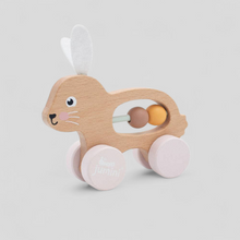 Load image into Gallery viewer, Wooden toy with pink wheels and a smiling face, push along bunny
