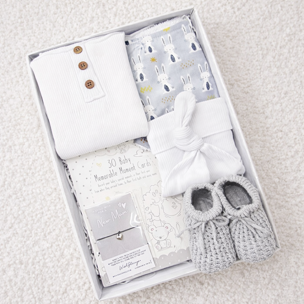 neutral baby gift box with cotton bodysuit hat booties milestone cards