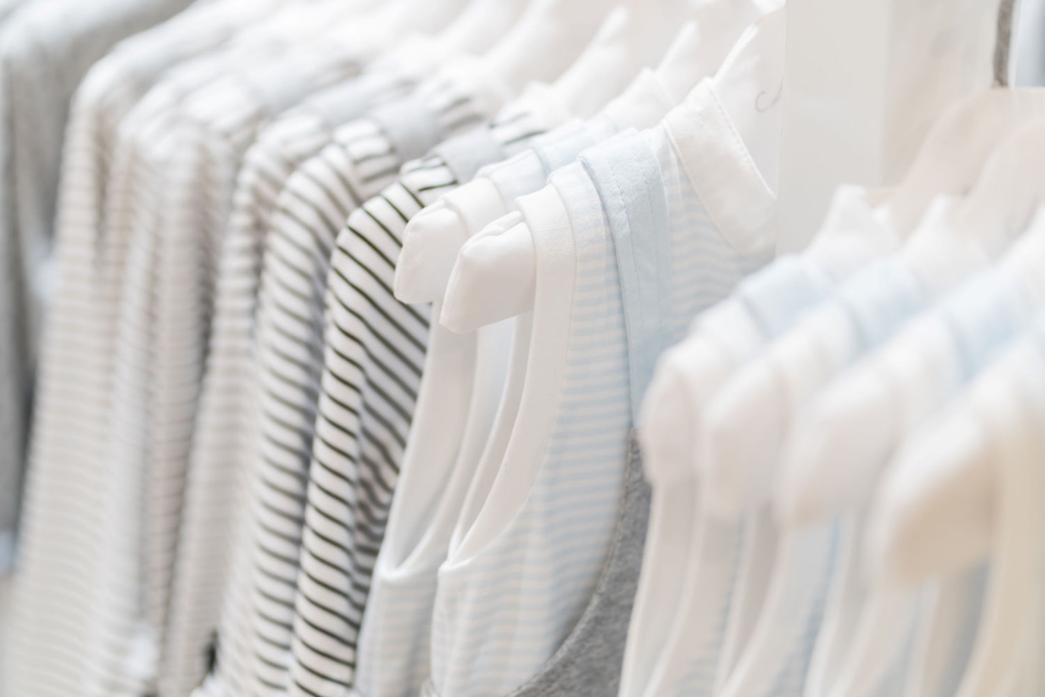 Newborn baby clothes – cotton bodysuits, sleepsuits, and outfit sets in pink, blue, and neutral tones from Ema and Boo