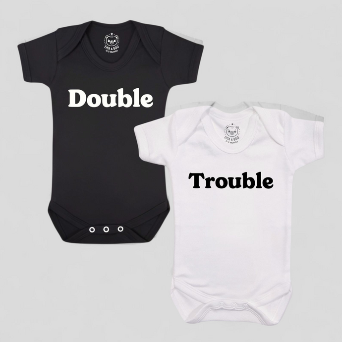 Black and white twin bodysuits with “Double” and “Trouble” print – gifts for newborn twins.