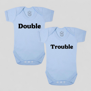 Blue cotton twin bodysuits with “Double” and “Trouble” text – newborn twins gift.