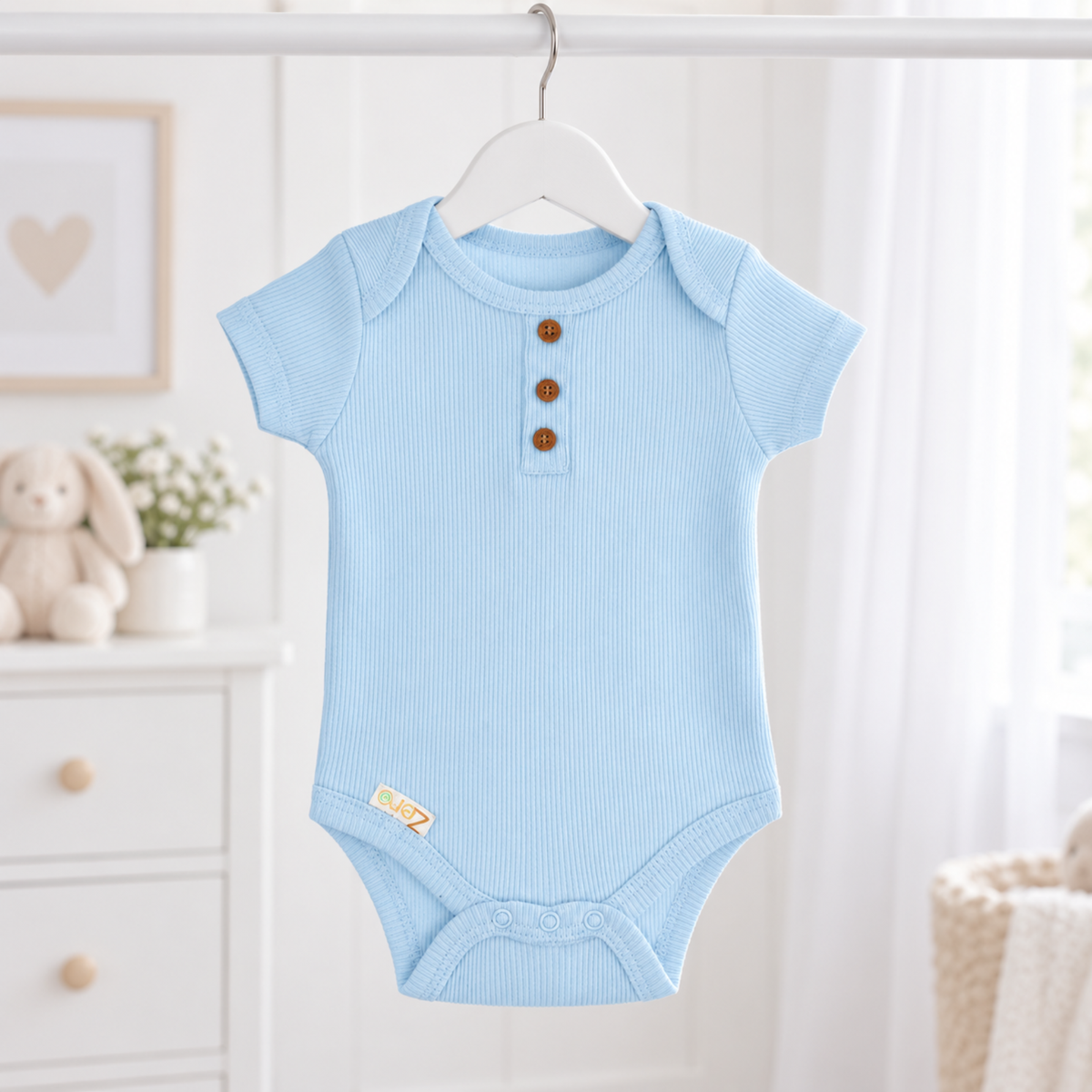 A light blue short-sleeve baby bodysuit with three brown buttons on the chest