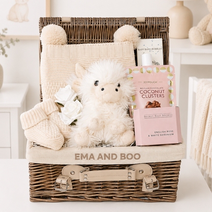 Luxury Highland cow new mum and baby hamper with premium newborn gifts and pamper treats in wicker hamper.