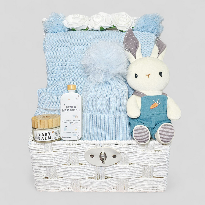Baby gift basket with plush toy, blanket, and skincare products 