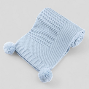 Light blue luxury knitted blanket with pom-poms 