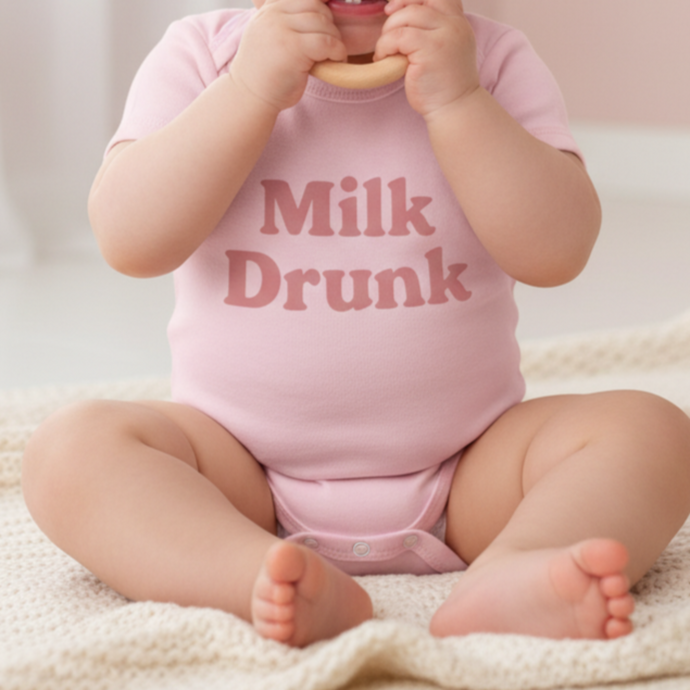 Pink Milk Drunk baby bodysuit with dusky pink writing