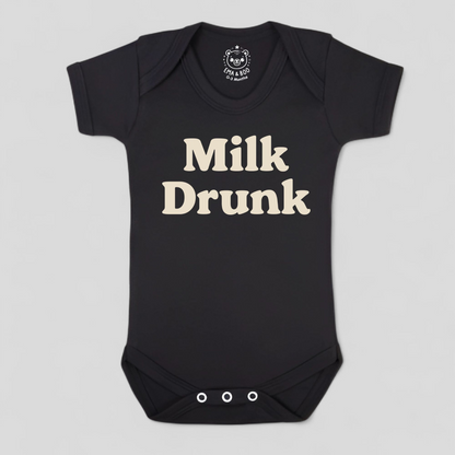 Black baby onesie with 'Milk Drunk' text 