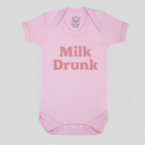 Pink baby onesie with 'Milk Drunk' text 