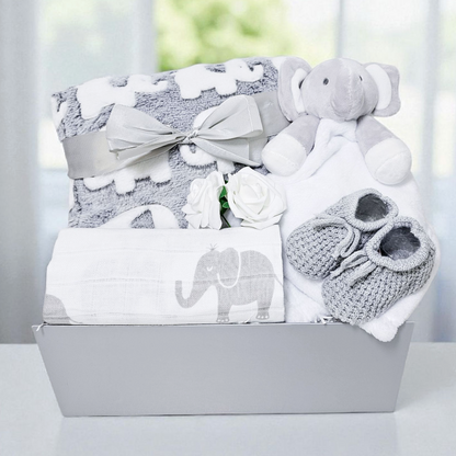 Neutral elephant-themed baby hamper with grey blanket, elephant comforter, muslin and booties in grey gift box.