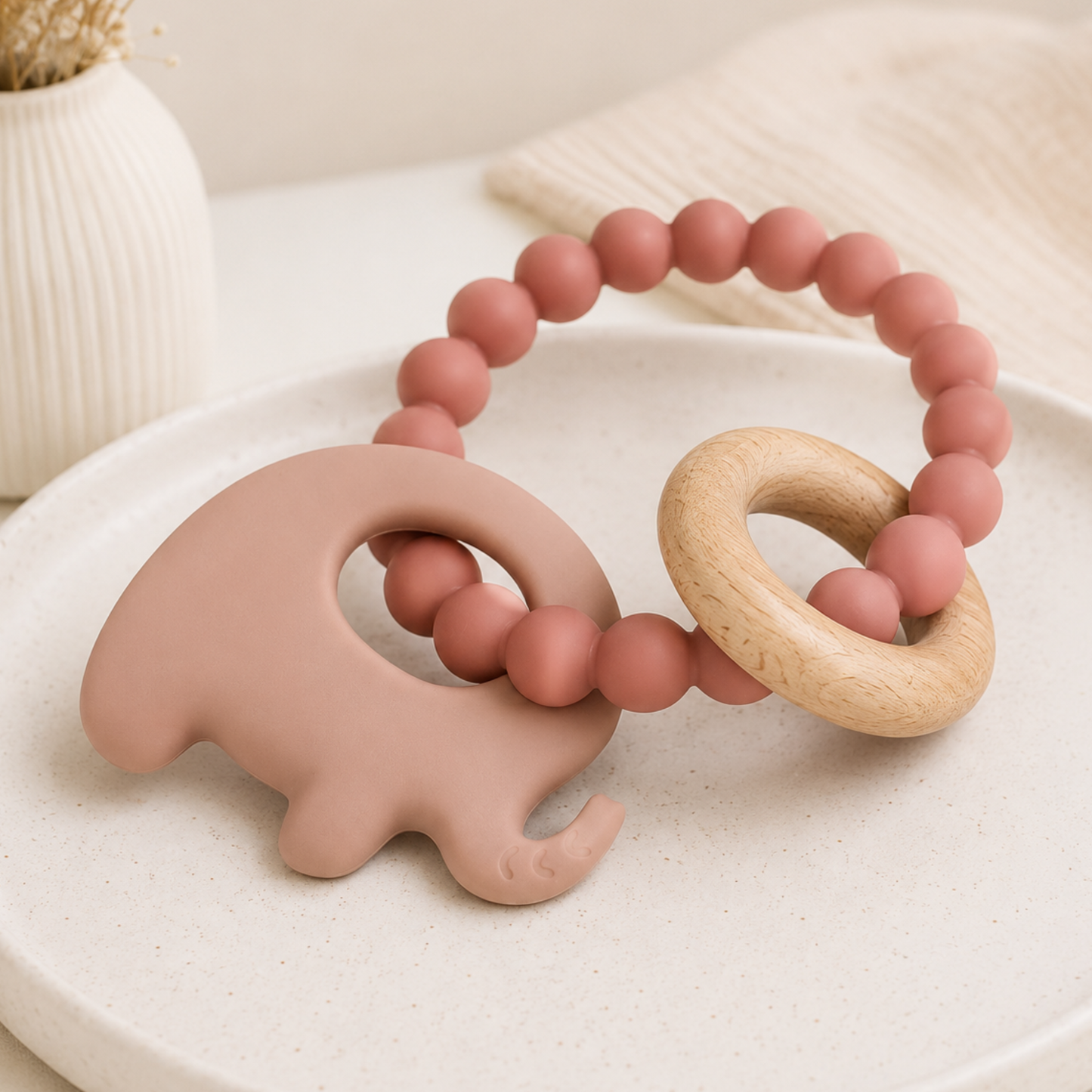 Silicone elephant teething ring with natural wooden ring designed to soothe baby's teething gums.