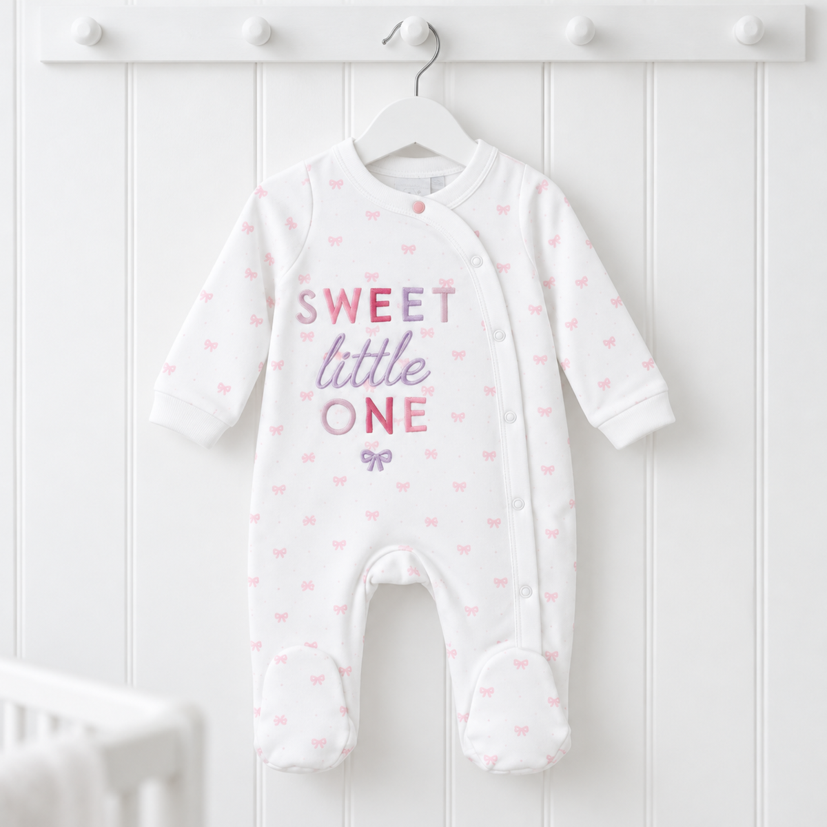 White cotton baby girl sleepsuit with pink bow print and embroidered Sweet Little One lettering, size 0–3 months