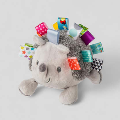 Plush hedgehog toy with colorful tags 