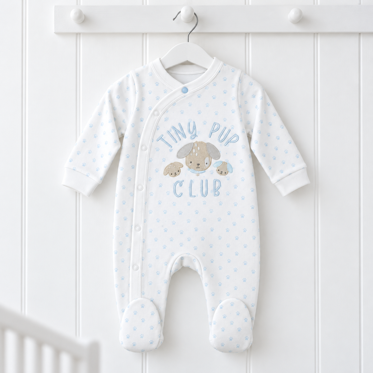 White and blue Tiny Pup Club cotton baby sleepsuit with embroidered puppy design and paw prints, 0–3 months