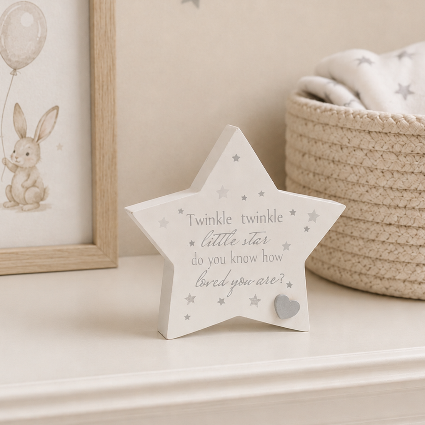 A white star-shaped decorative block with the phrase 'Twinkle twinkle little star do you know how loved you are?' 
