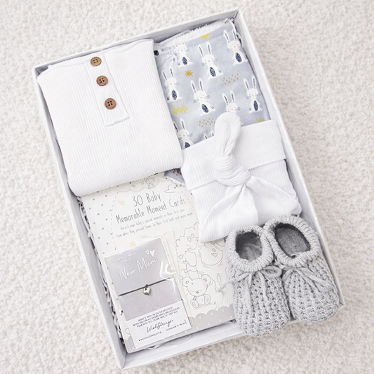 neutral baby gift box with cotton bodysuit hat booties milestone cards